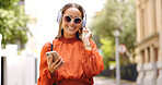 Music headphones, phone and woman dancing in city, having fun or happiness outdoor. Cellphone, dancer and happy person listening, streaming and enjoying radio, audio or sound podcast in urban street.