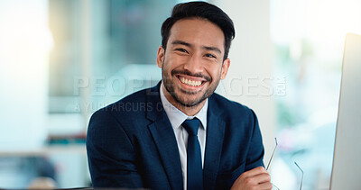 Buy stock photo Happy young business man looking ready for the day while working on a computer and smiling alone at work. Portrait of one corporate professional looking confident and successful in the office