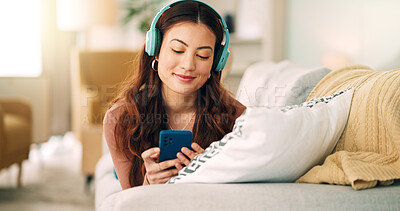 Buy stock photo Relax, music and phone with woman in living room and headphones listening to radio, podcast or podcast. Happy, freedom and internet with girl on sofa, streaming for audio, social media or online