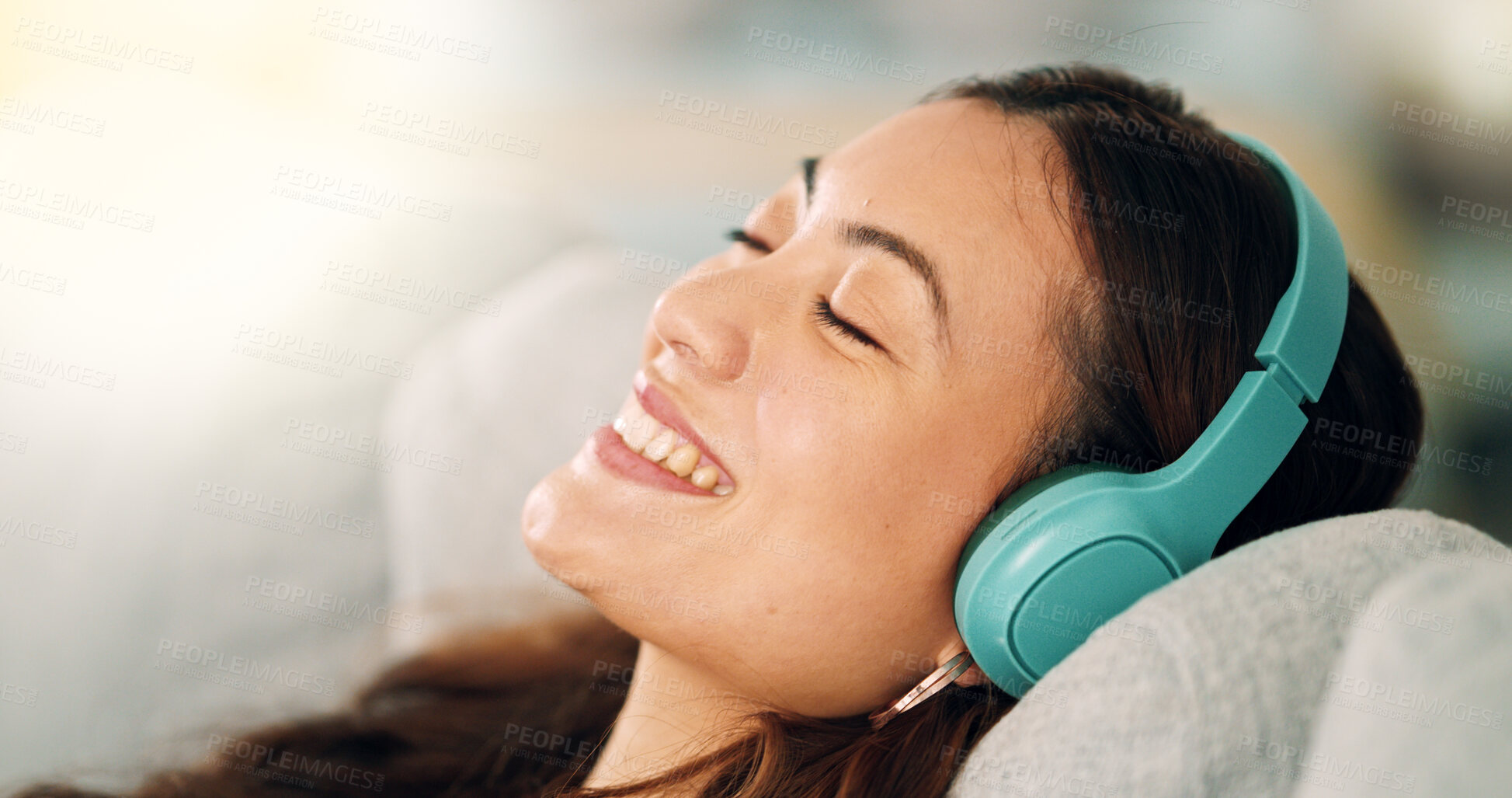 Buy stock photo Relax, headphones and happy woman listening to music, radio or podcast while resting on sofa. Happiness, smile and calm girl from singapore sitting on the couch in living room at home with technology