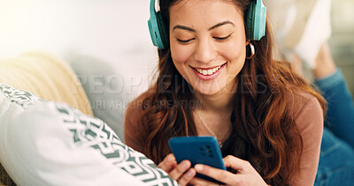Buy stock photo Girl, phone and music on sofa to relax with headphones with smile, typing and happy on social media. Woman, smartphone and streaming song on internet while reading communication, blog post or email