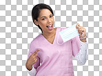 PNG cropped portrait of an attractive young female healthcare worker holding up and pointing to a mask in studio against a grey background