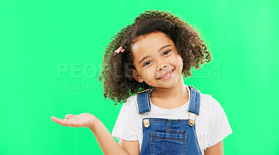 Happy, little girl and green screen with smile for product placement isolated against a studio background. Portrait of cute female kid smiling with palm of open hand showing advertisement on mockup