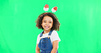 Portrait, children and cute with a girl on a green screen background in studio wearing a funky alice band. Kids, smile and innocent with an adorable little female child standing on chromakey mockup