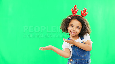 Christmas, green screen and a girl presenting advertising space for product placement in studio. Portrait, kids or celebration with an adorable little child on chromakey mockup for the festive season