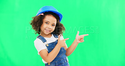 Children, construction and a girl on a green screen background in studio pointing at building space. Kids, architecture and design with a cute female child engineer wearing a hardhat on chromakey