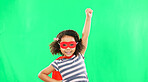 Child, superhero and hand to fly on green screen to stop crime and fight with fantasy or cosplay costume. Girl power, hero and game with smile of strong kid portrait to protect freedom and justice
