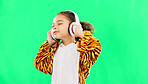 Children, music and dance with a girl on a green screen background in studio streaming audio while having fun. Kids, energy and freedom with a little female child dancing while listening to the radio