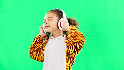 Children, music and dance with a girl on a green screen background in studio streaming audio while having fun. Kids, energy and freedom with a little female child dancing while listening to the radio