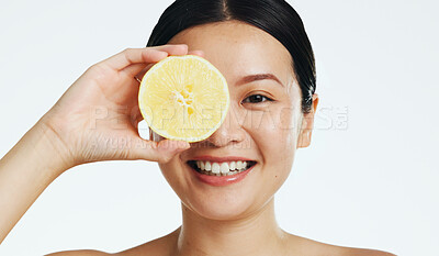 Lemon, face and woman in studio, natural wellness and white background. Happy asian model, beauty portrait and citrus fruits for facial cosmetics glow, vitamin c skincare or detox dermatology results
