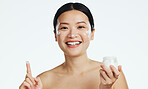 Face, lotion and beauty of asian woman, studio and isolated white background of aesthetic cosmetics. Portrait, facial cream and skincare jar of female model, sunscreen and happy dermatology product