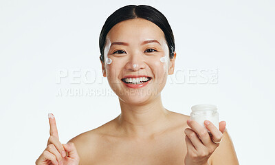 Face, lotion and beauty of asian woman, studio and isolated white background of aesthetic cosmetics. Portrait, facial cream and skincare jar of female model, sunscreen and happy dermatology product