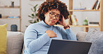 Laptop, bad news and loss with a woman on a sofa in the living room of her home feeling unhappy or emotional. Computer, shock and grief with a sad young female reading an email or social media feed