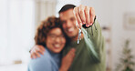 Hand, keys and a home owner couple proud of their real estate property investment or purchase. House, mortgage or beginning with a blurred background man and woman together in their new apartment