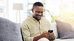 Black man, phone and smile on sofa for social media, communication or networking in living room at home. Happy African American male relaxing on couch with mobile smartphone for browsing or chatting