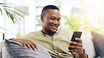 Black man, phone and smile on sofa for social media, communication or networking in living room at home. Happy African American male relaxing on couch with mobile smartphone for browsing or chatting