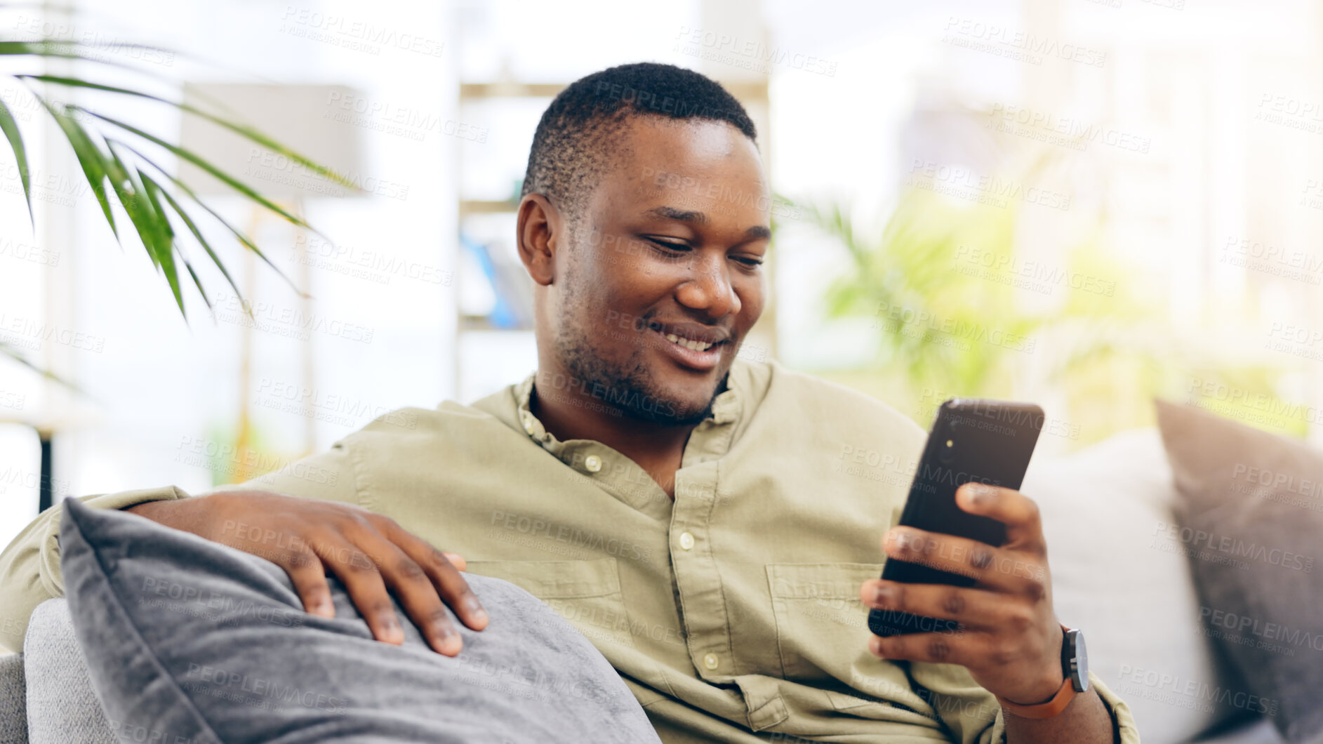 Buy stock photo Black man, phone and smile on couch for social media, communication or networking in living room at home. Happiness, African person relaxing on sofa with mobile smartphone for browsing or chatting