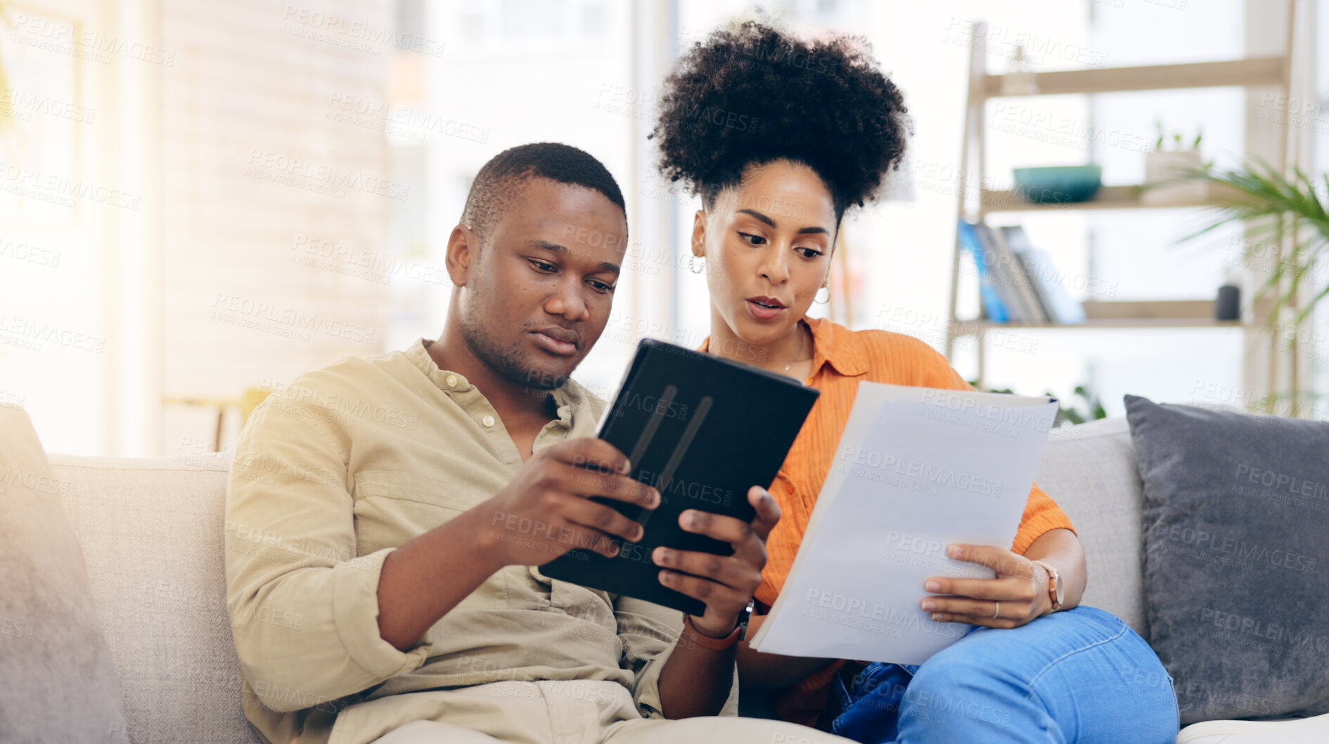 Buy stock photo Black couple, tablet and documents with financial crisis on living room sofa discussing mortgage payment. Home, African man and woman together with paperwork in debt, finance issue or money problems