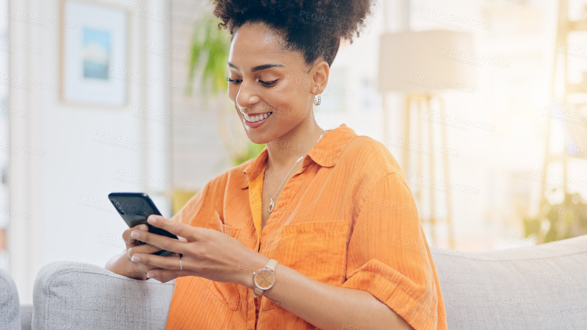 Buy stock photo Black woman, phone and smile on sofa for social media, communication or networking in living room at home. Happiness, African person relaxing on couch with mobile smartphone for browsing or chatting