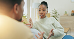 Black couple, argument and talking on sofa in conflict, disagreement or divorce in living room at home. Angry African American man and woman in fight for communication, disagree or arguing on couch