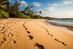 Summer, freedom and footprints in sand of beach for nature, explore and adventure. Ai generated, landscape and travel with footsteps following on coastline for seaside holiday, tropical and tourism