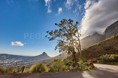Buy stock photo Copyspace and scenic landscape of a curved road and cloudy blue sky by Table Mountain in Cape Town, Western Cape. Bright sky, tree and quiet asphalt road in summer. Highway close to nature
