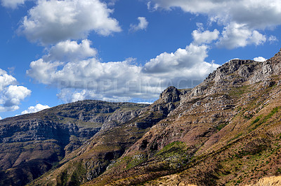 Buy stock photo Majestic mountain against a cloudy blue sky background. Beautiful view of mountain outcrops with hill covered with green vegetation on popular landmark or hiking location in Cape Town, South Africa