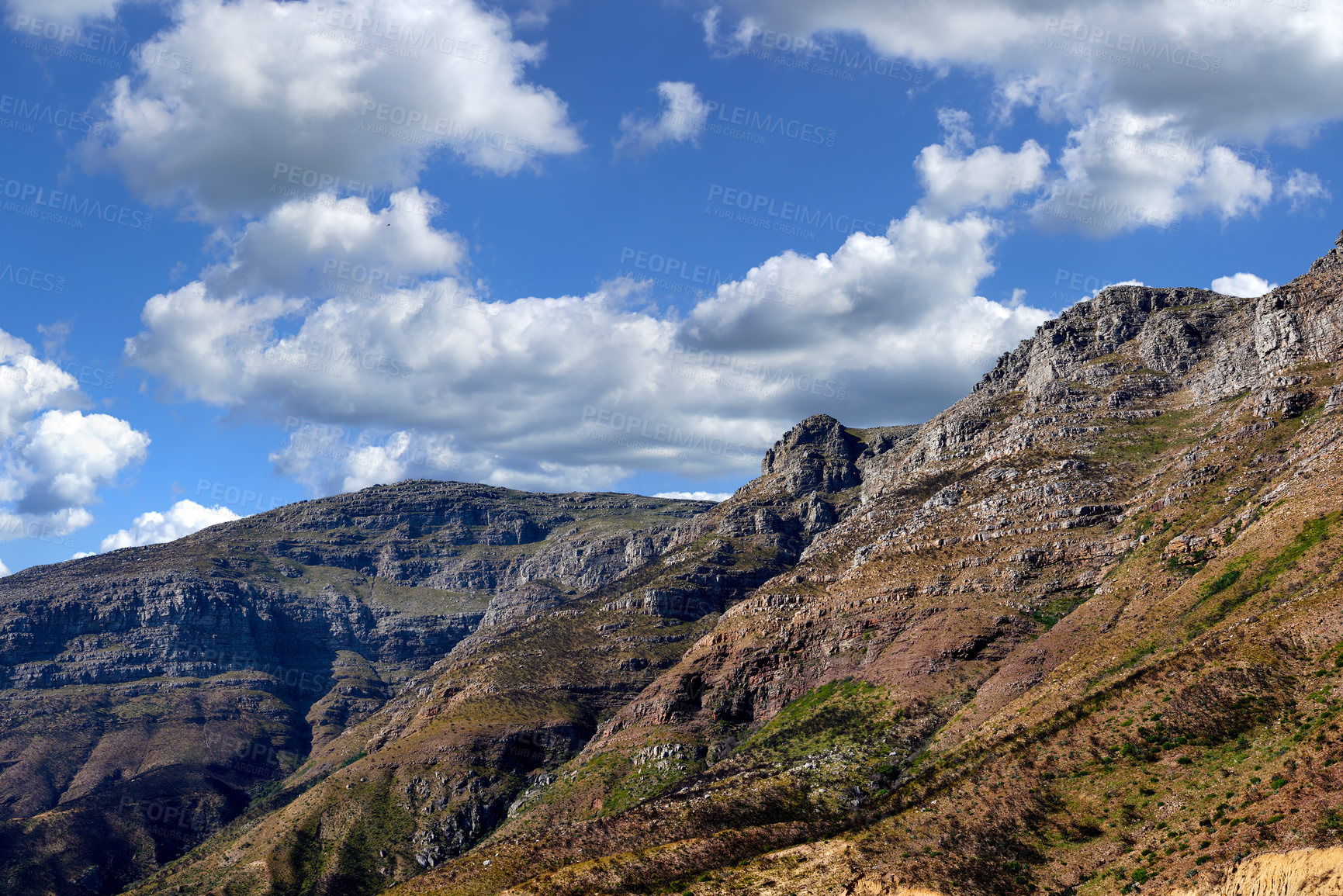 Buy stock photo Majestic mountain against a cloudy blue sky background. Beautiful view of mountain outcrops with hill covered with green vegetation on popular landmark or hiking location in Cape Town, South Africa