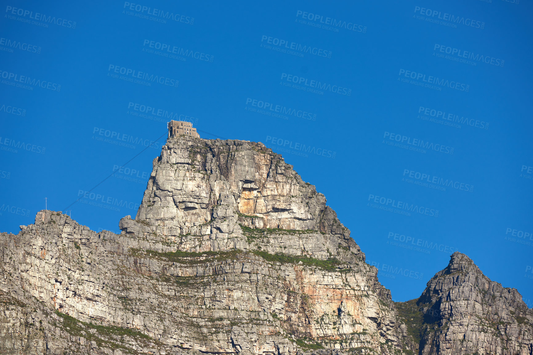 Buy stock photo A mountain cable car station for transporting tourists up Table Mountain, Cape Town to view nature. Low angle of rough, rocky, or dangerous terrain in a remote location with tropical weather