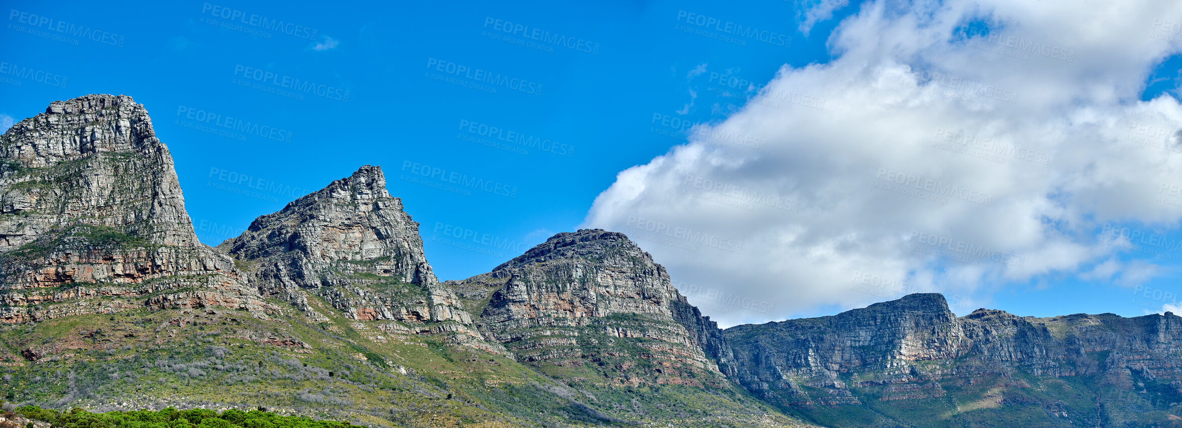 Buy stock photo Panorama of majestic mountains against a cloudy blue sky copy space. Beautiful view of The twelve apostles with hills covered in green grass on a popular landmark or sightseeing location in Cape Town