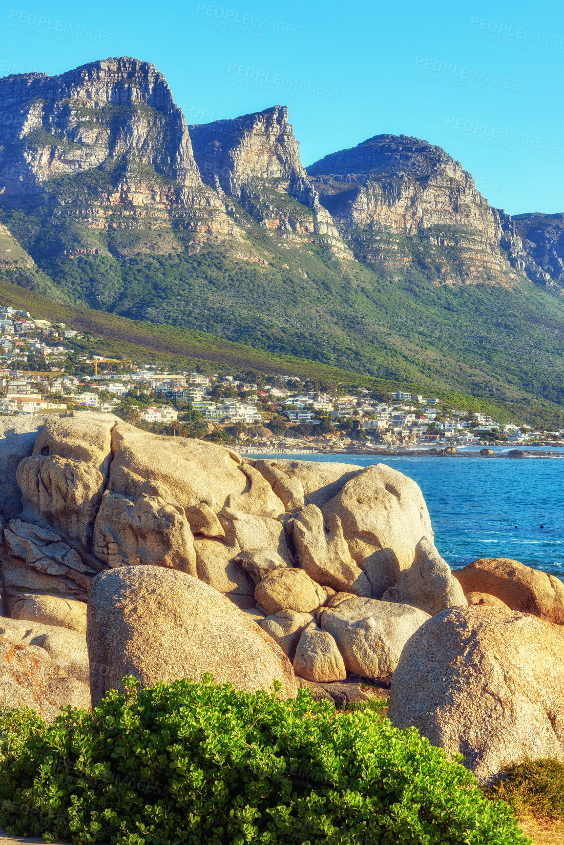 Buy stock photo Peaceful, quiet and remote natural area with mountains and the sea in summer. Beautiful, scenic landscape view of the seaside against a clear blue sky. Calm view of the ocean and plants in nature