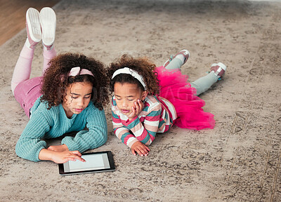 Buy stock photo High angle shot of two little girls playing on a digital tablet together at home
