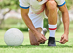 Sports, soccer and man tie shoe on field, ready for game, match and outdoor training. Fitness, exercise and soccer player tying shoelace on sneaker before workout on soccer field for good performance