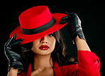 Fashion, woman and glamour in portrait with red hat or makeup in india with studio background. Elegant female, hidden and face with style with beauty or cosmetics with designer outfit and classy. 