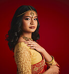 Fashion, culture and portrait of Indian woman with beauty in traditional clothes, jewellery and sari. Religion, Hindu and face of female person on red background with accessory, cosmetics and makeup