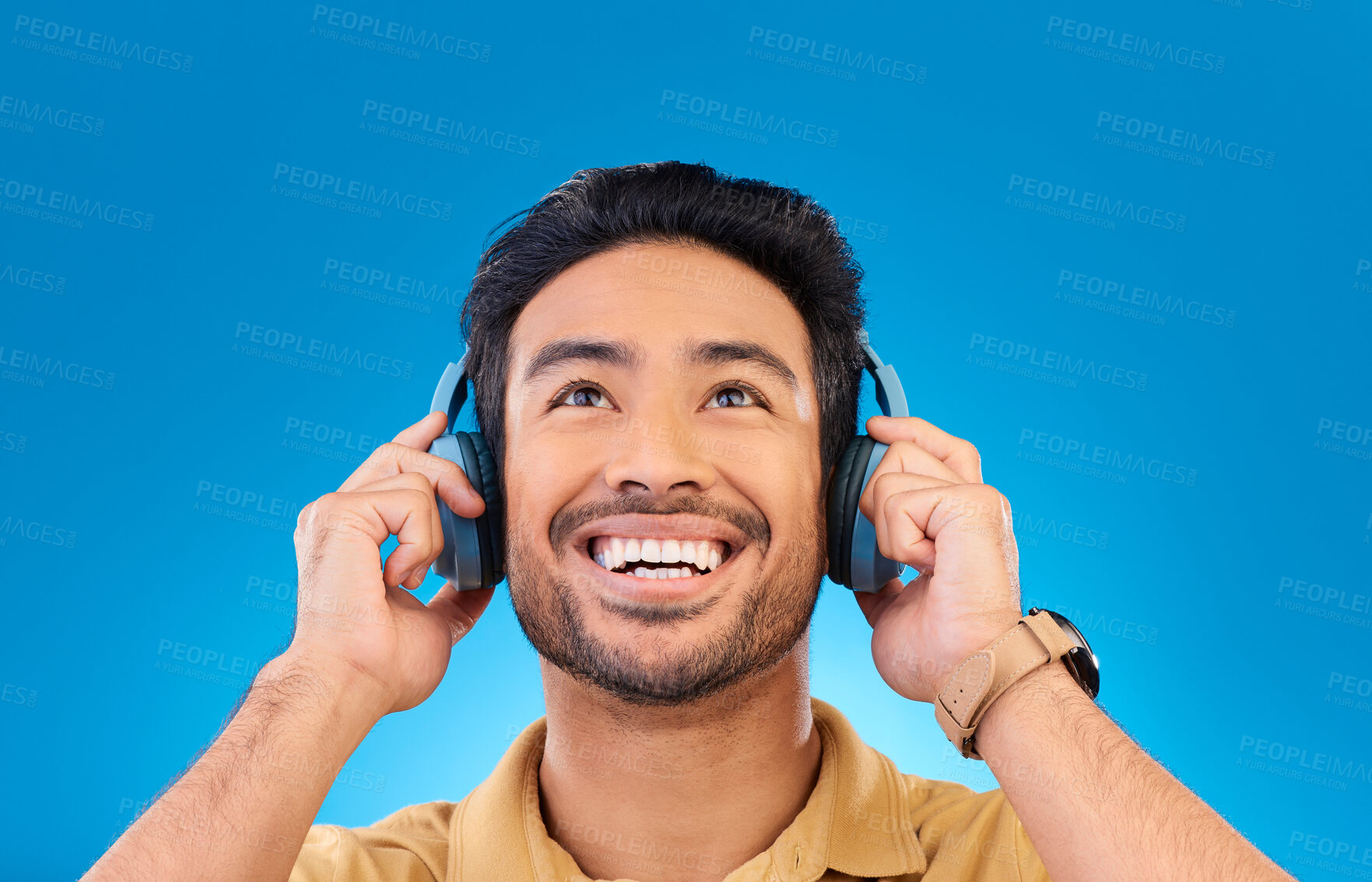 Buy stock photo Asian man, listening and music with smile for fun in blue background with radio or podcast. Happiness, guy and headphones for song or online streaming or entertainment in studio, track or media.