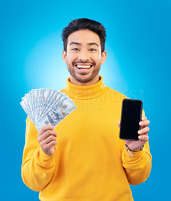 Buy stock photo Money, online and prize with portrait and asian man in blue background with for gambling or profit. Cash, winning and guy with fintech mobile app for competition or celebration with dollar in studio.