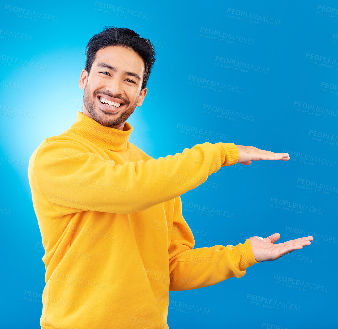 Buy stock photo Presenting, advertising and portrait of Asian man on blue background for news, showing and copy space. Studio, branding and face of male person with hand gesture for promotion, deal and presentation