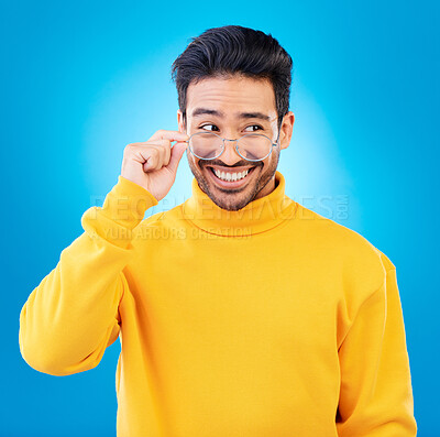 Buy stock photo Thinking, glasses and Asian man with ideas, solution and happiness against a blue studio background. Male person, option and model with eyewear, opportunity or choice with a smile and problem solving