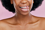 Black woman, mouth and tongue out, beauty and teeth with dental, health and hygiene on pink background. Lips, skin and African female model, oral care and grooming with healthy gums in studio