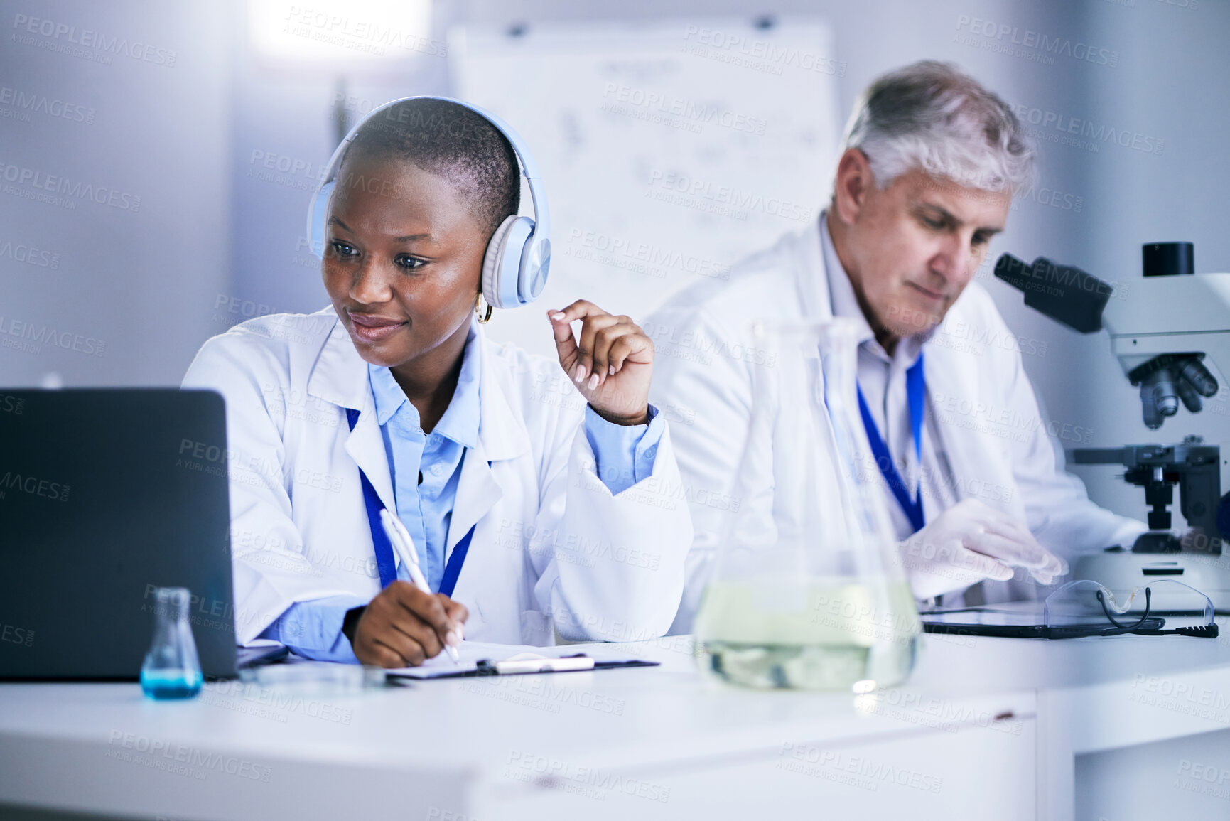 Buy stock photo Science, laptop and people writing in a laboratory with internet, medical research or results. Man and black woman scientist or doctor with tech and headphones for scientific innovation or planning