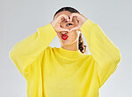 Woman, portrait and heart hands for love, care or romance in casual fashion against a grey studio background. Female person with loving emoji, hand gesture or sign and symbol for healthy wellness