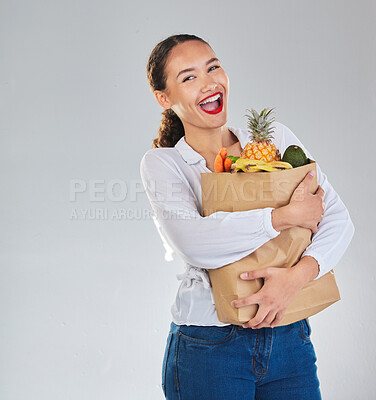 Buy stock photo Excited, portrait and woman grocery shopping for fruit on mockup space in studio isolated on a white background. Bag, food or customer with vegetables for nutrition, healthy diet and supermarket deal