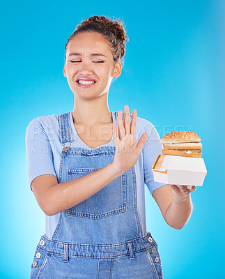 Buy stock photo Burger, no and woman reject fast food choice and unhappy gives bad, disgust and frustrated review for diet protection. Disaster, mistake and person disappointed isolated in a studio blue background