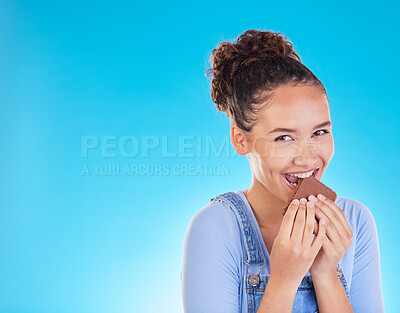 Buy stock photo Chocolate, diet and space with portrait of woman in studio for fast food, dessert and nutrition. Happy, cacao and sugar with person eating on blue background for candy, health and hungry mockup