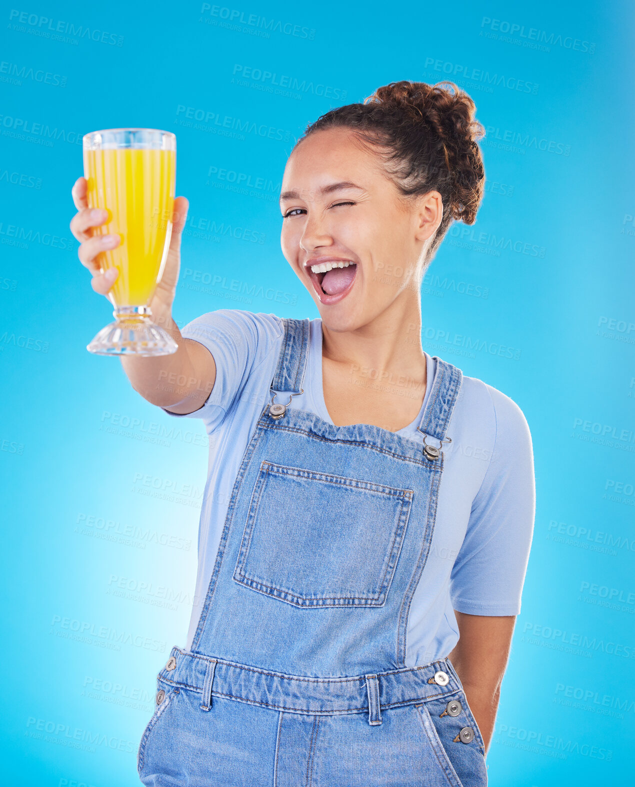 Buy stock photo Happy woman, portrait and juice for vitamin C, diet or healthy drink against a blue studio background. Female person or model with denim fashion holding glass with organic fruit blend or breakfast