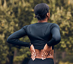 Back pain, fitness and sports woman outdoor for scoliosis, health risk and tired from running in park. Female athlete, runner and exercise injury of muscle, joint problem and first aid for hurt spine