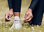 Lace sneakers, person and hands outdoor on grass for running, workout and performance. Closeup of athlete, runner and tie shoes on feet, footwear and exercise at park for sports, fitness and marathon