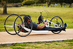 Health, disability and fitness with man and bike with handicap for training, sports and challenge. Exercise, workout and wheelchair with disabled person cycling in park for cardio and wellness