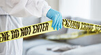 Forensics, crime scene and tape with person in living room for investigation, research and safety. Medical, science and evidence with closeup of investigator for examination, police and security